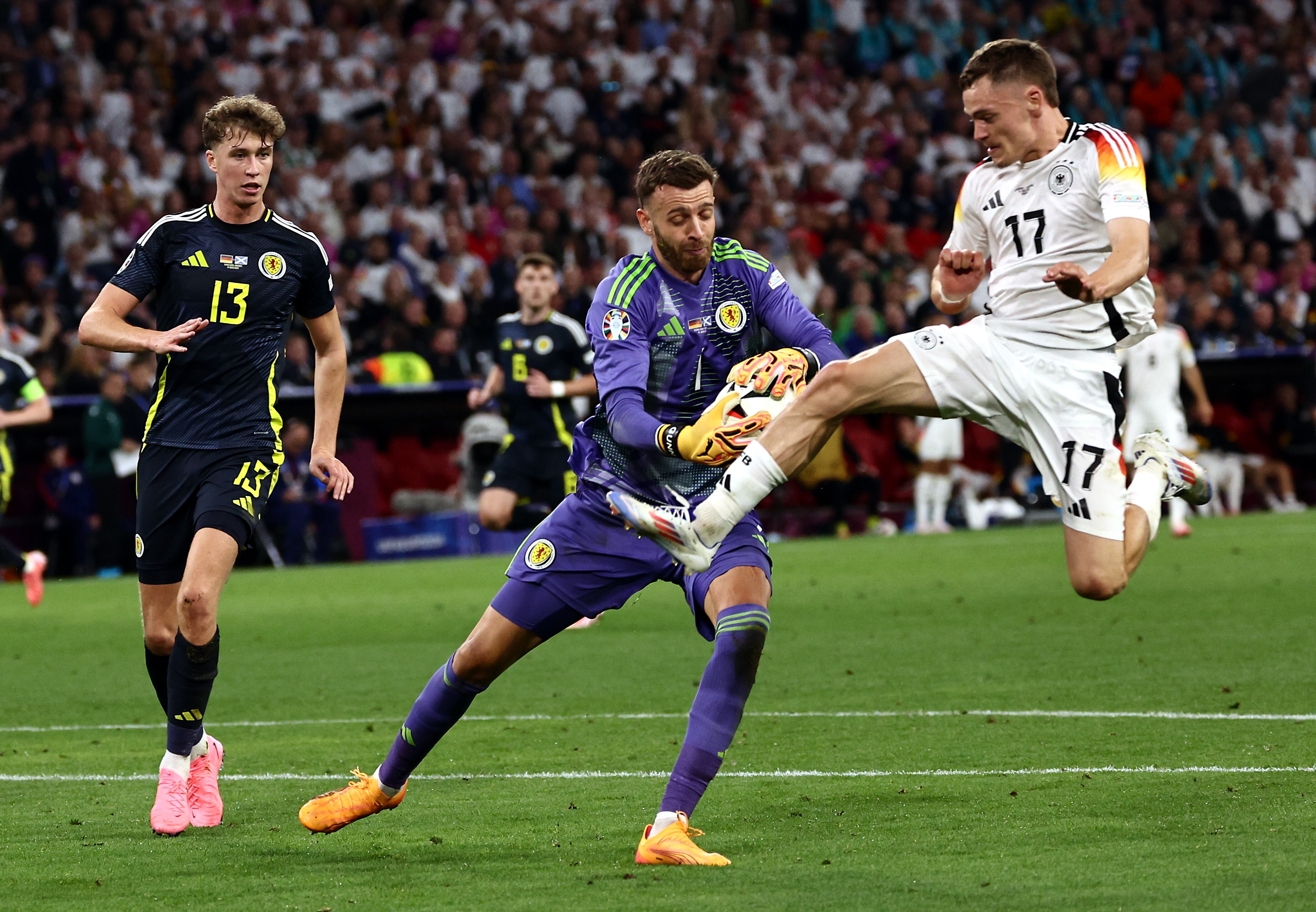 Angus Gunn, portero de Escocia, controla la pelota ante  Florian Wirtz de Alemania.