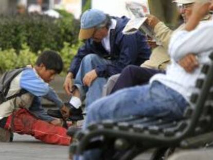 Un niño lustra botas trabaja en una calle de Quito (Ecuador). EFE/Archivo