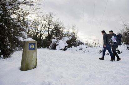 Dos peregrinos coreanos caminan por el Alto de Erro (Navarra), el 17 de enero de 2015.