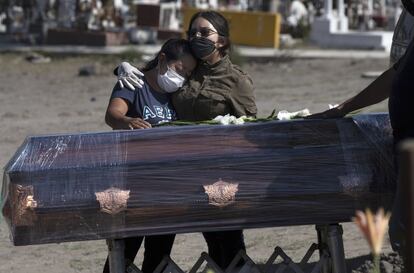 Familiares de una víctima del coronavirus se abrazan, durante el funeral, en el cementerio Valle de Chalco, a las afueras de Ciudad de México.