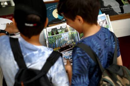 Dos niños disfrutan del salón del libro juvenil en el Centro Cultural Conde Duque.