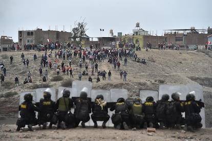Un grupo de policías se resguarda detrás de sus escudos, en Arequipa, al sur de Perú.