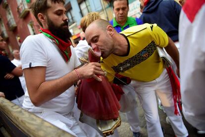 Un corredor besa la imagen de San Fermín momentos antes de participar en el encierro, el 14 de julio de 2017.