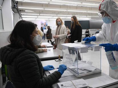 Un trabajador desinfecta una urna electoral en un colegio de Barcelona.