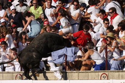 Caras de pánico en la grada de sol, en la plaza de Tafalla. Los espectadores inician la huida mientras el toro termina de 'aterrizar' sobre la grada.
