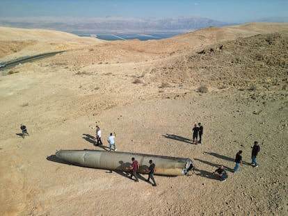 Varias personas, alrededor de los restos de un misil balístico iraní en el desierto, cerca de la ciudad sureña de Arad (Israel).