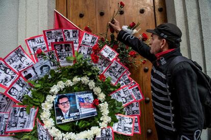 Un hombre coloca una flor al lado de una corona para honrar al fallecido expresidente Salvador Allende durante una manifestación frente al palacio presidencial La Moneda, en Santiago.