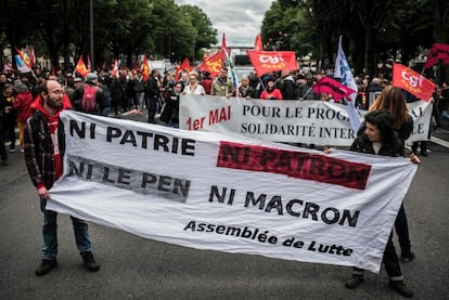 Manifestantes sostienen una pancarta donde se lee "No patria ni jefe, ni Le Pen ni Macron" en referencia a los dos candidatos presidenciales franceses durante la marcha tradicional de trabajadores en Lyon.