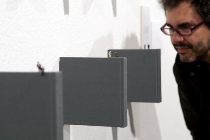 El artista observa la obra 'Libros ensimismados'. "Los libros están tratados como si fueran sabiduría, como unas cápsulas que contienen todo lo que hemos sido a lo largo de nuestra historia", explica Rosales. En esta instalación los libros flotan en la pared, y sobre ellos se sostienen figuras de personas. Y es que, como dice el autor, "los libros se pueden sostener por sí mismos porque tienen toda esa sabiduría dentro".