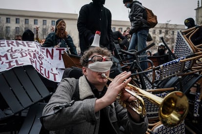 A man plays the trumpet in front of a barricade during a demonstration in Lyon, central France, on Tuesday, March 7, 2023.