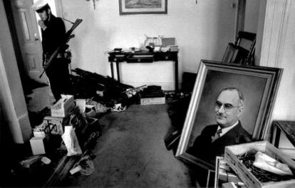 Un soldado vigila una sala de la policía política portuguesa PIDE, con un retrato del ex primer ministro Marcelo Caetano tirado en el suelo, en la mañana de la Revolución de los Claveles.