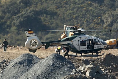 Un Guardia Civil baja una caja de explosivos de un helicóptero, empleados para las labores de rescate.