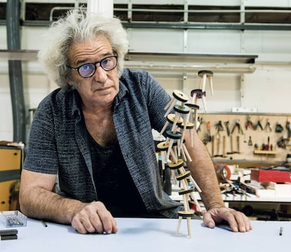 Javier Bermejo poses in front of the game The Stools, a construction game where players balance each piece on top of each other.