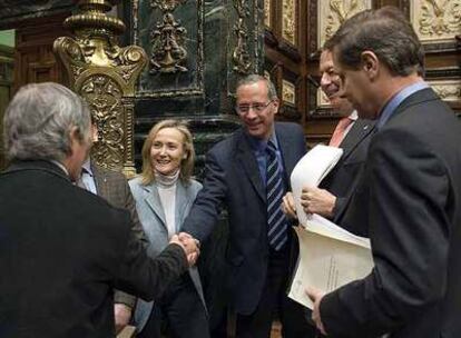 Xavier Casas, en el centro, saludando a Xavier Trias (de espaldas), presidente del grupo municipal de CiU.