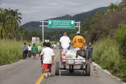 Habitantes de las zonas afectadas por las lluvias en Guerrero salen de Coyuca, un municipio en la zona más dañada. Los carros tirados por burros y los tractores se han convertido en medios de trnasporte alternativos.