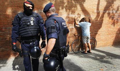 Dos agentes de los Mossos identifican a un manifestante.