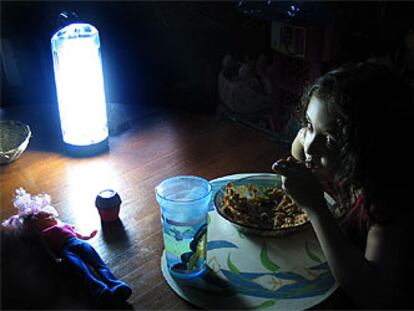 Una niña come bajo la luz de una linterna en La Habana durante el apagón del pasado viernes.

.