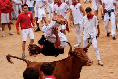 A reveller jumps over a 'vaquilla' (young cow) inside the bullring at the Sanfermines festival in Pamplona on Monday. 