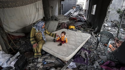 Una mujer palestina y su hijo, en el interior de una casa bombardeada en Gaza. Imagen tomada por el fotógrafo palestino Ali Jadallah.