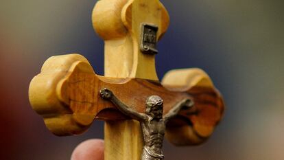 A woman holds a crucifix