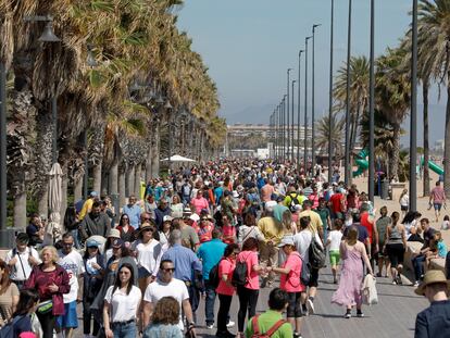 Cientos de personas pasean el domingo por el paseo marítimo de la playa de la Malvarrosa, en Valencia, en un día en que las temperaturas ya rondaron los 30 grados.
