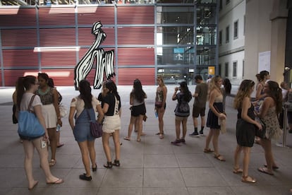 Un grupo de jóvenes turistas esperan para comprar su entrada del Museo Reina Sofía junto a la escultura 'Brushstroke' de Roy Lichtenstein.