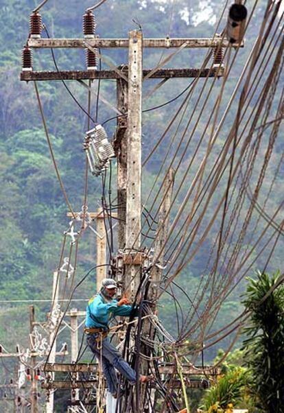 Un trabajador tailandés arregla líneas eléctricas en Khao Lak.