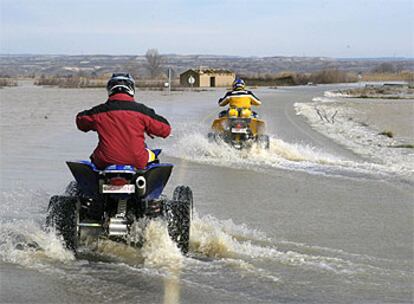 Las aguas del Ebro inundaron ayer la carretera A-1107 a su paso por la localidad zaragozana de Pina.