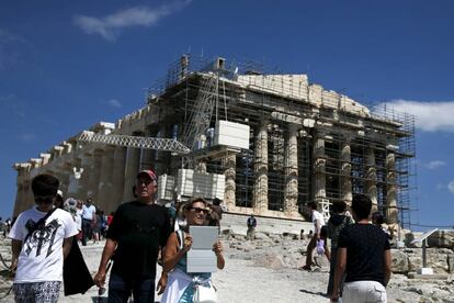Los turistas visitan el templo del Partenón en la Acrópolis de Atenas, Grecia.