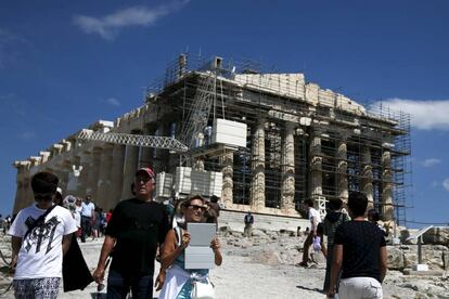 Los turistas visitan el templo del Partenón en la Acrópolis de Atenas, Grecia. 