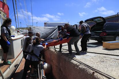 La tripulación del 'Astral' y los efectivos de la Guardia Costera italiana trasladan el cadáver a tierra firme, en el puerto de la isla de Lampedusa. Fue el día siguiente al hallazgo del cuerpo cuando los miembros de la ONG recibieron por fin la autorización para entregarlo. El ahogado fue posteriormente transportado en un coche fúnebre al hospital de la isla, donde se le practicaría la autopsia.  