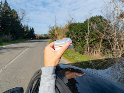 El brazo de una persona colocando la baliza en el techo de su coche.