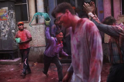 Un hombre lanza agua coloreada sobre la gente en una calle de Vrindavan (India), durante la celebración del festival Holi, 27 de marzo de 2013.