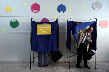Ciudadanos utilizan las cabinas de votación en un colegio electoral en Atenas (Grecia).