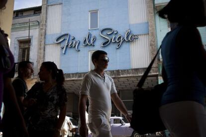 Pedestrians walk by a pre-revolutionary department store in Havana.