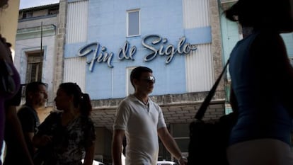 Pedestrians walk by a pre-revolutionary department store in Havana.