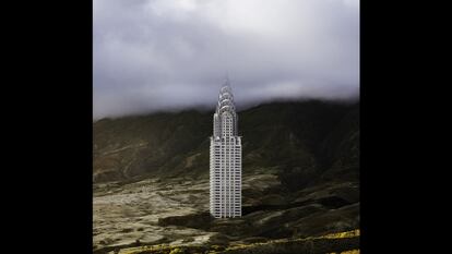 El esbelto edificio Chrysler emerge de la tierra en un paisaje montañoso. Su estructura art déco penetra en la bruma de las cumbres.