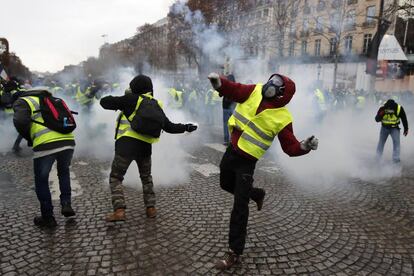 Manifestantes lanzan gas lacrimógeno a la policía francesa durante la protesta en el centro de París.