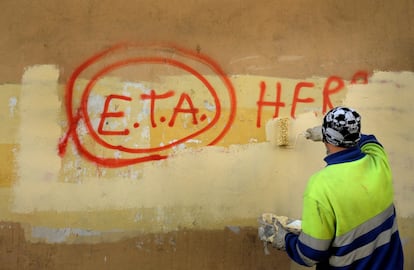 Un empleado municipal retira una pintada en Guernica. 