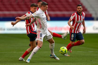 Kroos protege el balón ante Marcos Llorente este domingo en el Wanda.