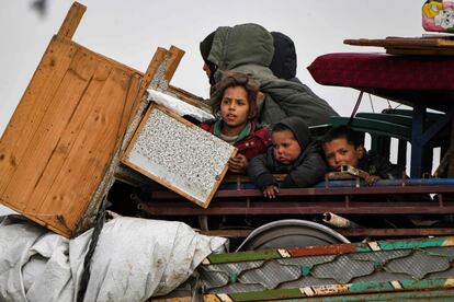 Varios niños viajan en la parte trasera de un camión con muebles, colchones y mantas cerca de la frontera turca en el oeste de la provincia norteña de Alepo, el 16 de febrero.