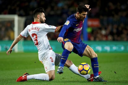 El delantero argentino Leo Messi (d), del FC Barcelona, lucha un balón con Rubén Duarte, del Deportivo Alavés, durante el partido de la vigésimo primera jornada del Campeonato Nacional de Liga que se disputa en el Camp Nou, en Barcelona.