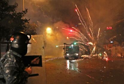 Los partidarios de los grupos chiítas Hezbolá y Amal lanzan fuegos artificiales a las fuerzas de seguridad en el centro de Beirut. El presidente de Líbano pospuso ayer la consulta para seleccionar un nuevo primer ministro después de semanas de protestas callejeras.