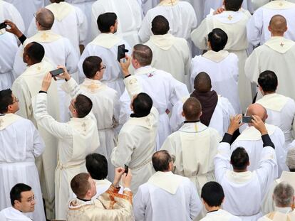 Sacerdotes sacan fotos con sus móviles durante la misa oficiada por el papa Francisco antes de la apertura de la Puerta Santa en 2019.