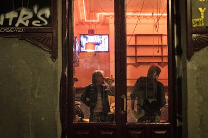 Los miembros del colectivo 'El Cártel' realizan una pausa durante el empapelado de las calles de Malasaña, en uno de los bares del barrio.