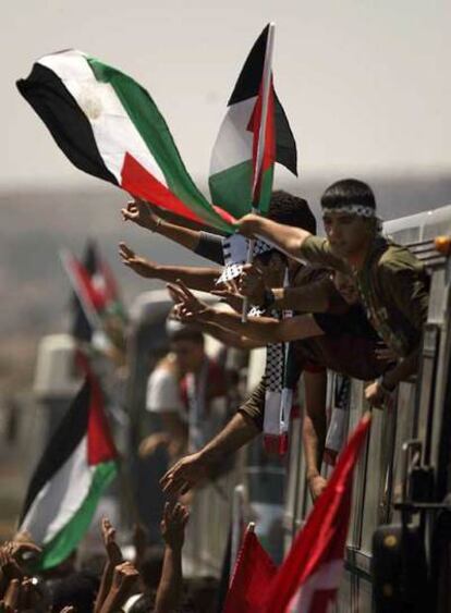 Los presos palestinos liberados por Israel saludan desde el autobús en que viajan a Ramala.