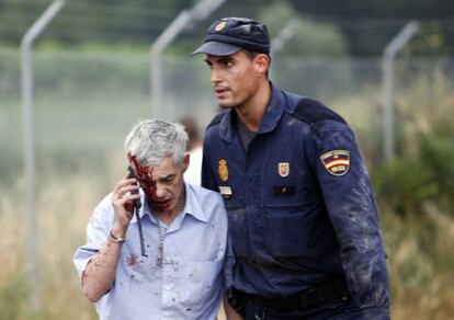 Train driver Francisco José Garzón is helped by a policeman after Wednesday's crash.