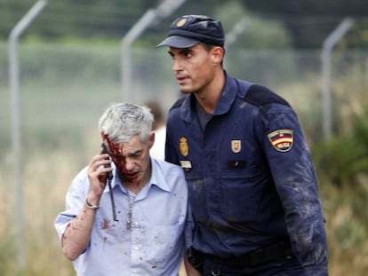 Train driver Francisco Jos&eacute; Garz&oacute;n is helped by a policeman after Wednesday&#039;s crash.