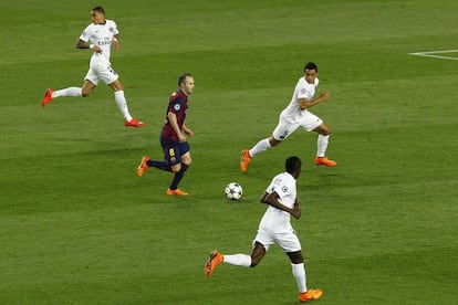 Iniesta condueix la pilota envoltat de jugadors del PSG, dimecres al Camp Nou.