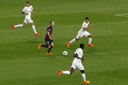 Iniesta conduce el balón rodeado de jugadores del PSG, el miércoles en el Camp Nou.